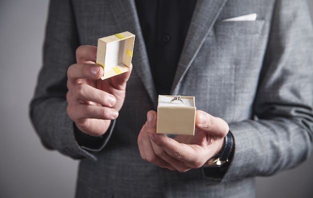 Hombre sosteniendo una caja con anillo de bodas.