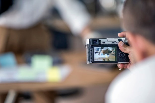 Foto hombre sosteniendo la cámara de vitage y tomando fotos