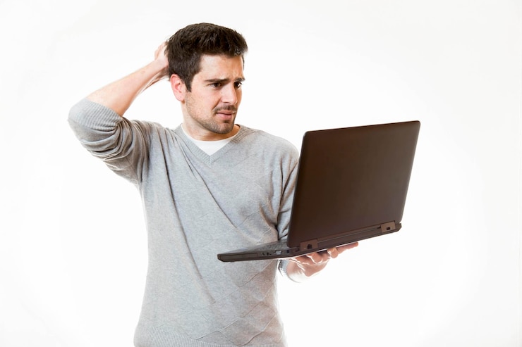 Foto hombre sosteniendo una computadora portátil mientras está de pie contra un fondo blanco