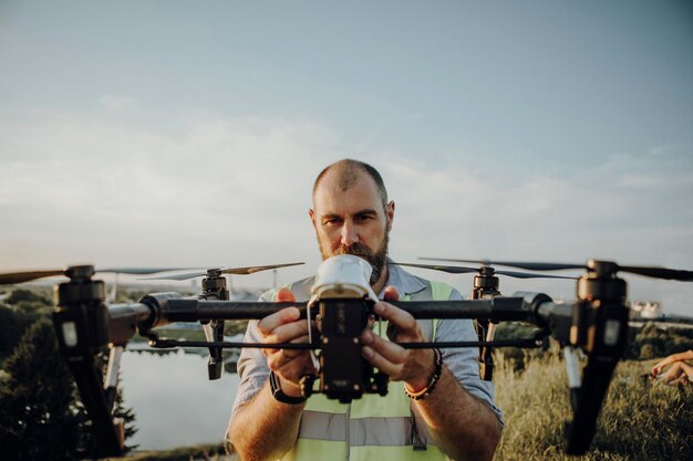 Foto hombre sosteniendo un dron mientras está de pie contra el cielo