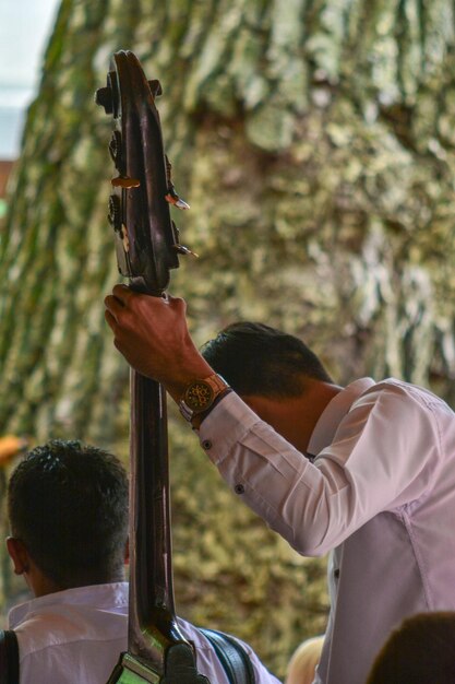 Foto hombre sosteniendo un instrumento musical durante el evento