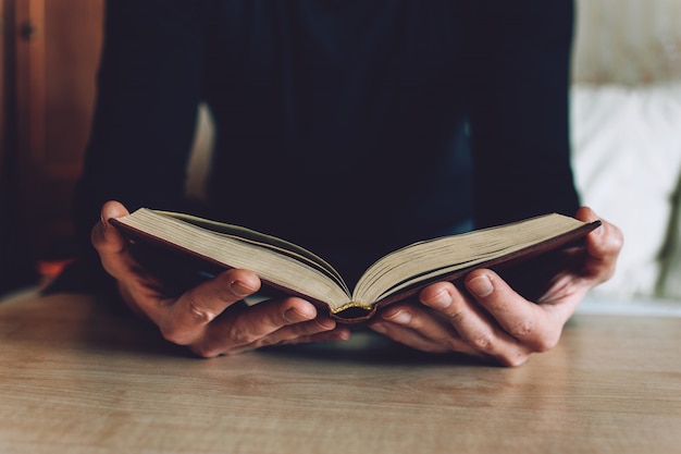 Hombre sosteniendo libro abierto en las manos