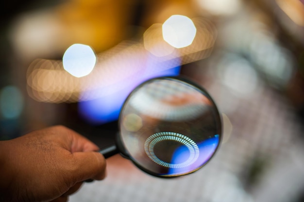 Hombre sosteniendo una lupa frente a un círculo brillante