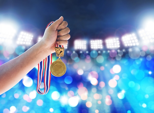 Hombre sosteniendo una medalla de oro en contra, ganar el concepto.