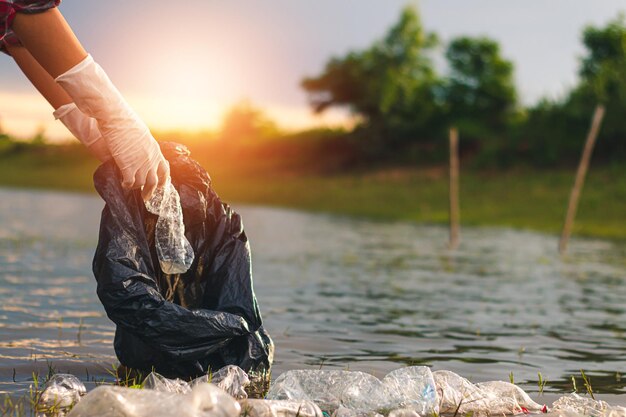 Foto hombre sosteniendo un paraguas junto al río contra el cielo durante la puesta de sol