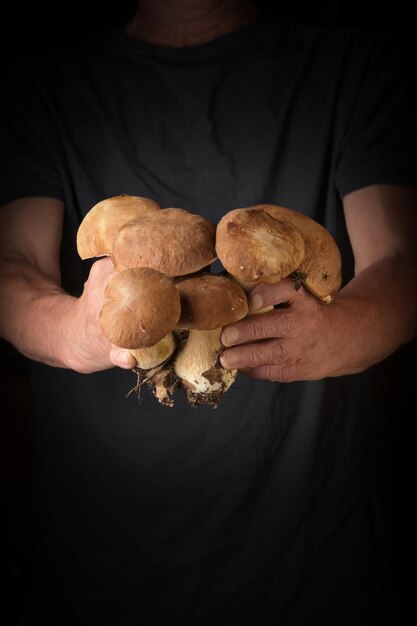 Foto hombre sosteniendo el rey bolete en la mano estilo rústico