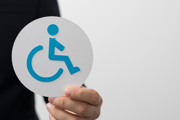 Hombre sosteniendo un signo de círculo con un símbolo de discapacidad