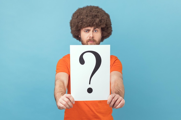 Foto hombre sosteniendo un signo de interrogación encontrando una solución inteligente pidiendo consejo mirando a la cámara