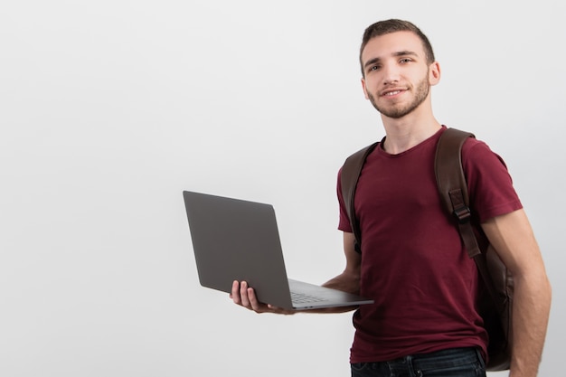 Hombre sosteniendo su laptop y mirando a cámara