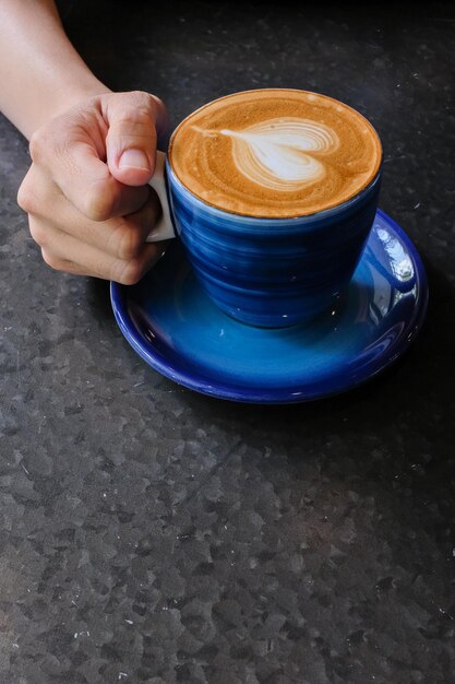 Hombre sosteniendo una taza de café en la mesa