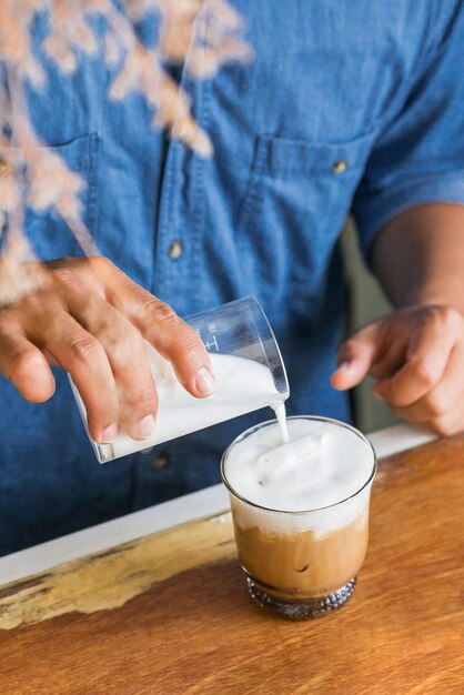 Foto hombre sosteniendo una taza de café en la mesa