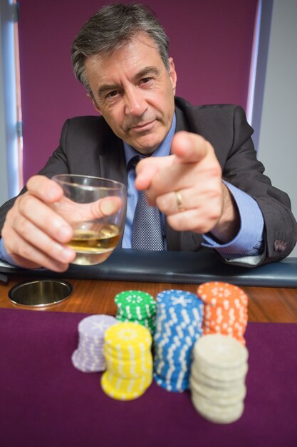 Foto hombre sosteniendo un vaso y apuntando