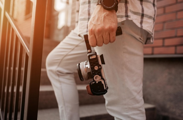 El hombre sostiene una cámara digital para grabar contenido de video