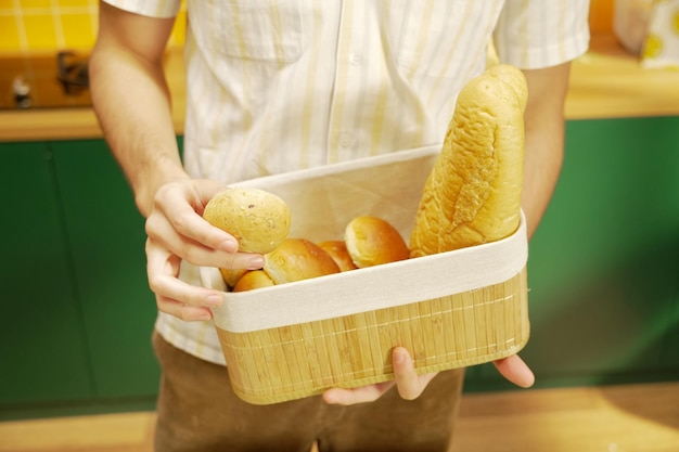 Un hombre sostiene una canasta de pan y pan.