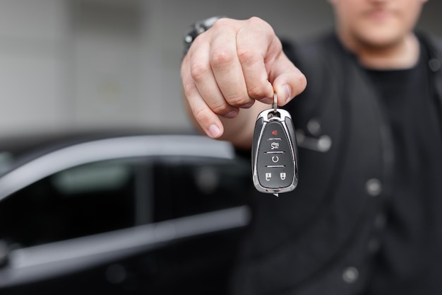 Foto el hombre sostiene y da las llaves del coche alquiler de automóviles y prueba de conducción