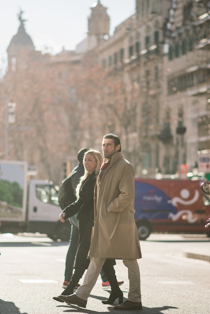 El hombre sostiene la mano de su esposa y la mira tiernamente y camina por las calles de la ciudad.