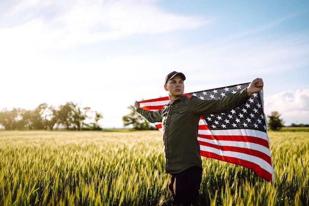 El hombre sostiene ondeando la bandera estadounidense de EE. UU. Patriot levanta la bandera nacional estadounidense Día de la Independencia 4 de julio