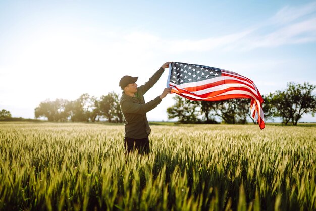El hombre sostiene ondeando la bandera estadounidense de EE. UU. Patriot levanta la bandera nacional estadounidense Día de la Independencia 4 de julio