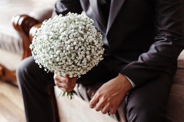 Un hombre sostiene un ramo de novia.