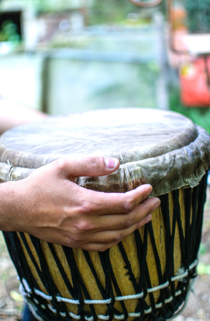 Un hombre sostiene un tambor con la palabra djembe.