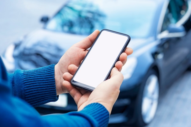 El hombre sostiene el teléfono inteligente con una pantalla en blanco