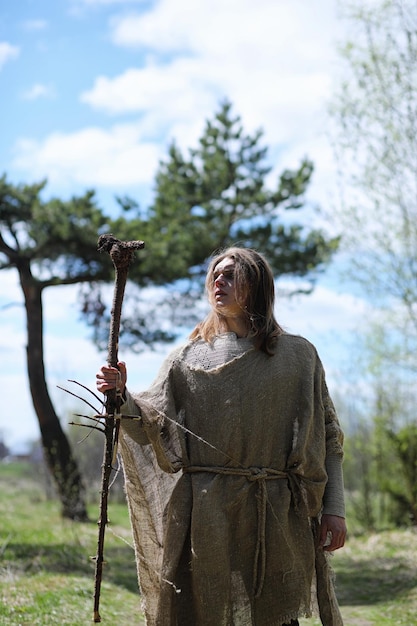 Un hombre con sotana pasa un ritual en un bosque oscuro