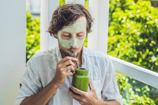 Hombre de spa aplicando máscara facial de arcilla verde.