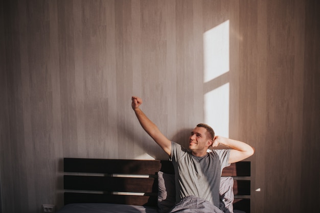 Un hombre en su cama por la mañana.