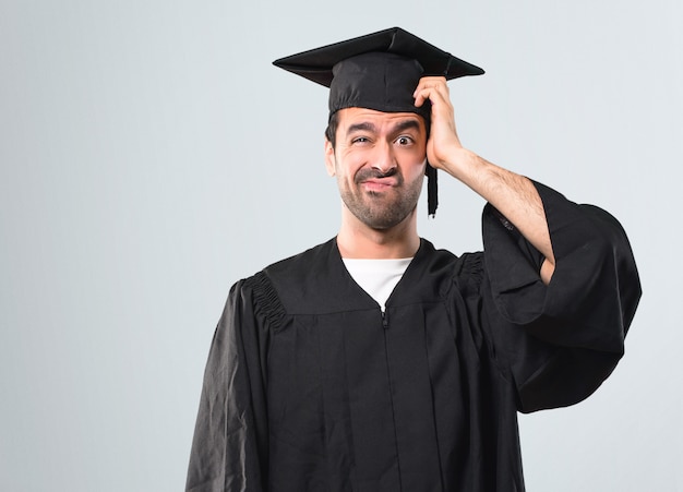 Hombre en su día de graduación Universidad con una expresión de frustración y no entiende