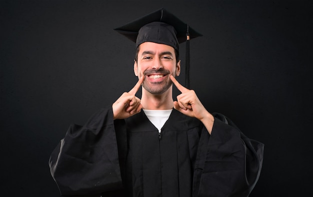 Hombre en su día de graduación Universidad sonriendo con una expresión feliz y agradable