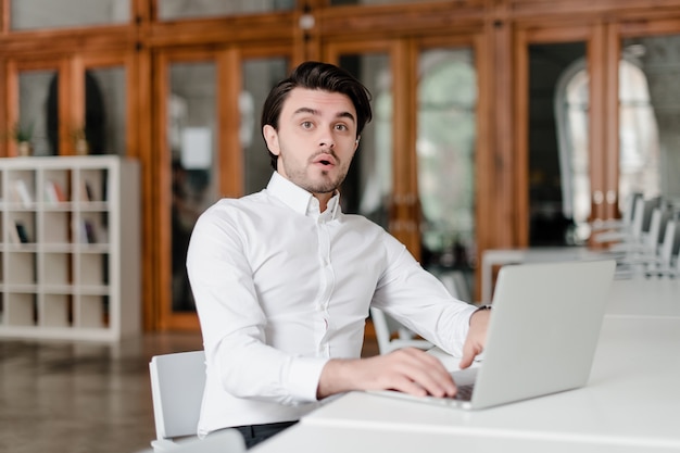 Hombre en su lugar de trabajo con laptop en la oficina