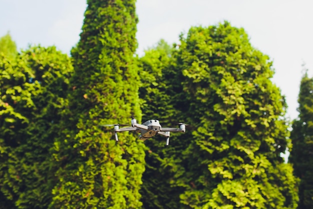 El hombre y su quadrocopter drone en un bosque sobre un fondo verde