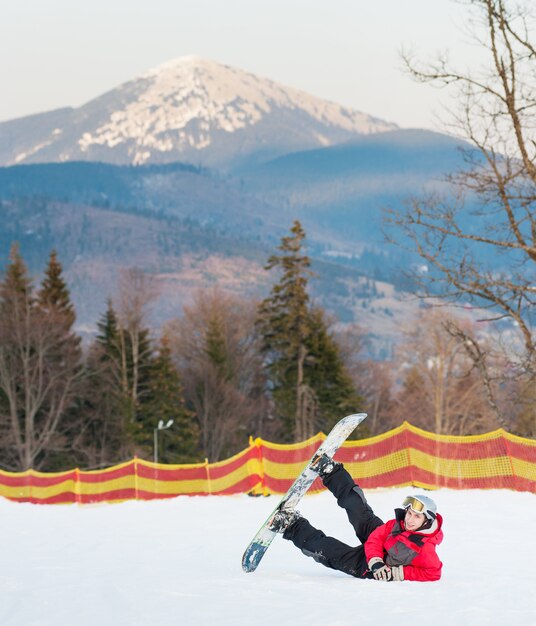 Hombre con su tabla de snowboard en la pista de esquí