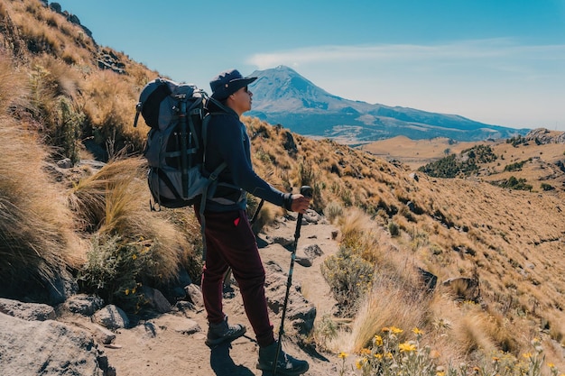 Un hombre subiendo una colina en las montañas del volcán iztaccihuatl