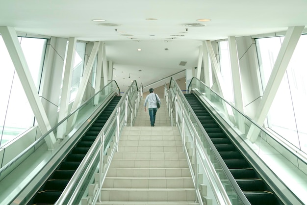 Hombre subiendo las escaleras dentro de un edificio moderno