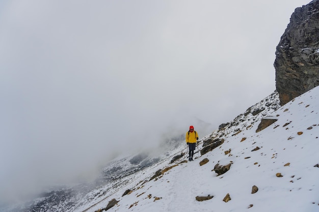 Hombre subiendo pendiente nevada