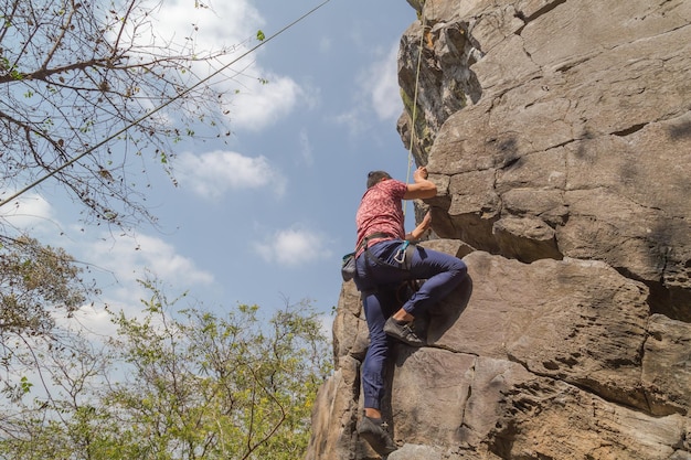 Hombre subiendo en una roca impresionante