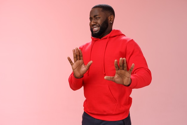 Hombre con una sudadera roja sobre rosa