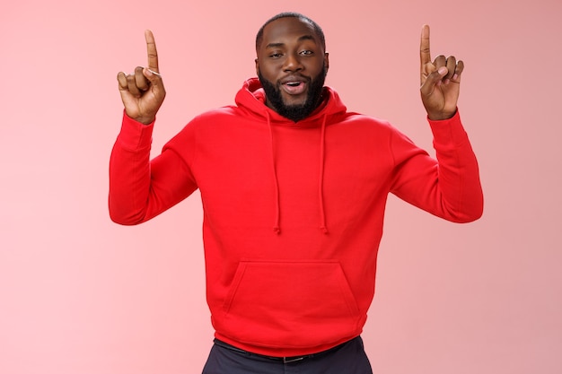 Hombre con una sudadera roja sobre rosa