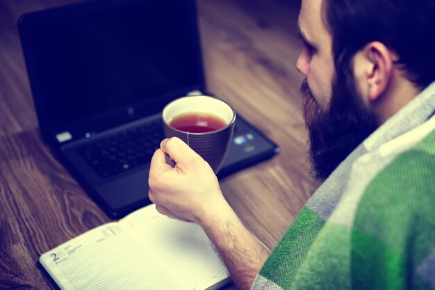 El hombre en el suelo frente a la computadora