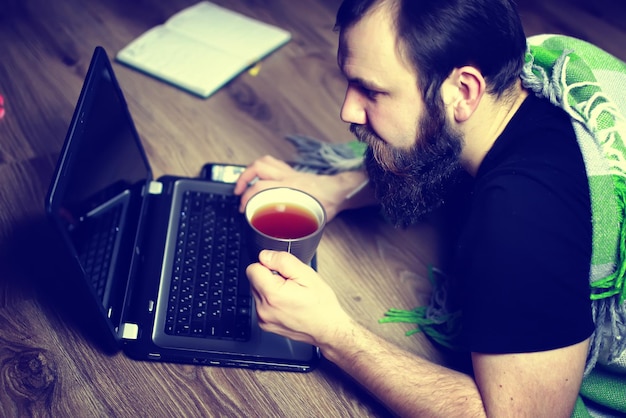 El hombre en el suelo frente a la computadora