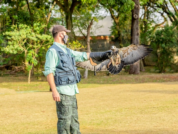 Hombre sujetando un águila blackchested