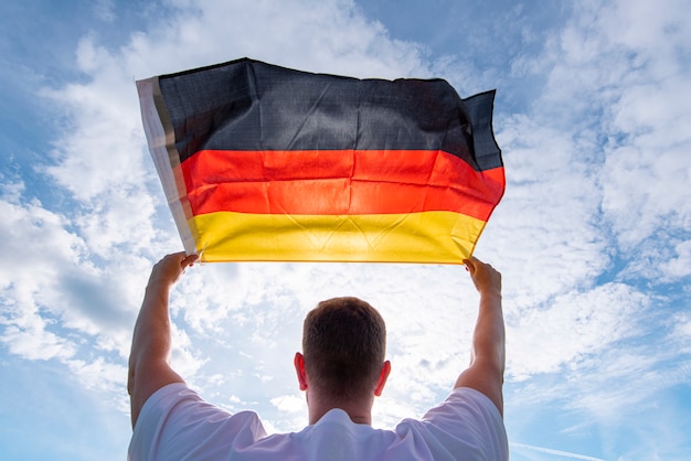 Hombre sujetando la bandera de Alemania, imagen conceptual