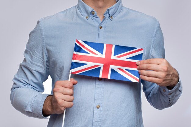 Hombre sujetando la bandera del Reino Unido. Estudio de la lengua inglesa. Emigración a Reino Unido.