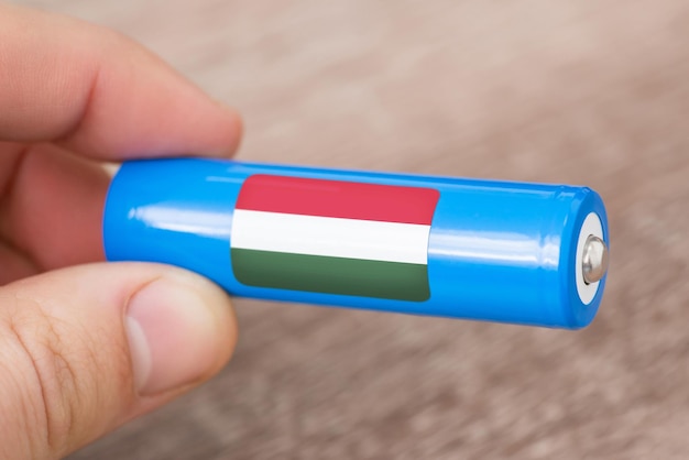 Hombre sujetando una batería de iones de litio recargable con bandera de Hungría