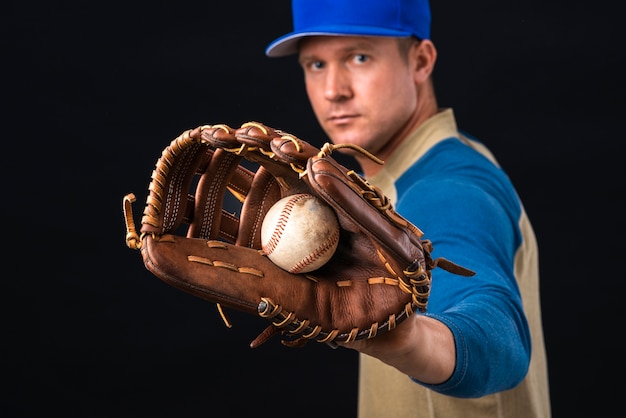 Hombre sujetando béisbol y guante