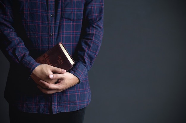 Hombre sujetando una biblia, cree concepto espacio de copia.