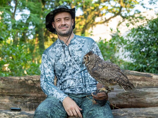 Hombre sujetando un búho Bubo virginianus