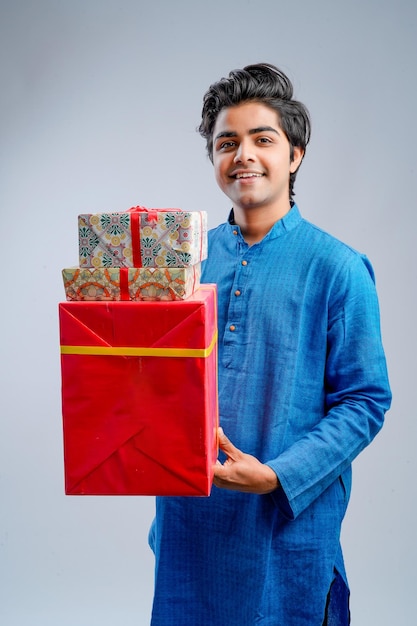 Hombre sujetando cajas de regalo y lámpara durante el festival Diwali