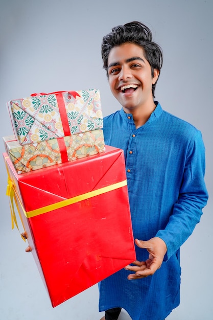 Hombre sujetando cajas de regalo y lámpara durante el festival Diwali